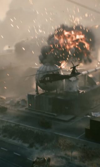 Military helicopter on a rooftop helipad as a large explosion erupts at an industrial facility with fire and smoke filling the sky.