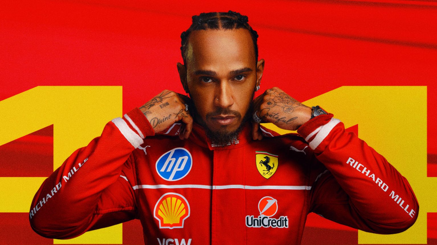 Lewis Hamilton seduto davanti a uno sfondo rosso con il numero 44.