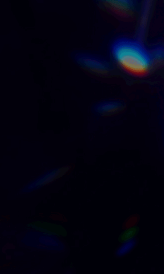 Dark abstract background with diagonal rainbow-colored light streaks spreading from the center. No visible text or logos. The overall tone is deep blue and black with multicolored highlights.