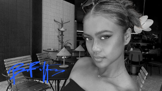 Bianca Bustamante's selfie picture in black and white. Her signature in blue is at the bottom left. She is looking into the camera with her hair up in a bun.