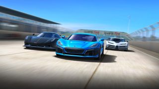 Image of a blue, black and white racing cars speeding on a race track on a bright day with the blue car leading.