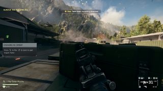 In-game screen from Battlefield 6. A soldier crouches behind cover, aiming a weapon towards a combat zone. Player objectives and hints are seen on screen.