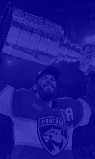 NHL 26 standard cover athlete Matthew Tkachuk lifting the Stanley Cup trophy over his head in blue.