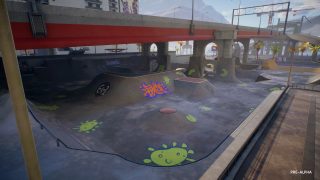 Concreted skatepark with graffiti under bridge.