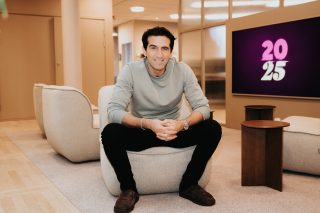 Foto van Josef Fares zittend in een informele kantooromgeving met zijn gezicht naar de camera